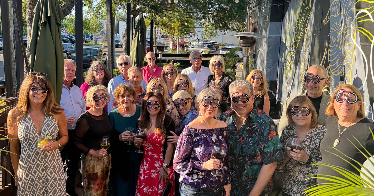 Outdoor dining area with decorative pillows, lanterns, and tropical plants
