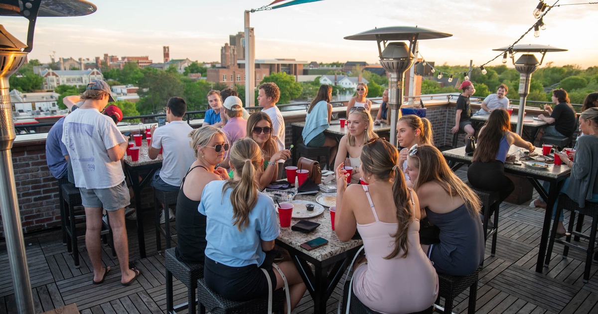 People enjoying themselves on a bar terrace over drinks in the afternoon sun