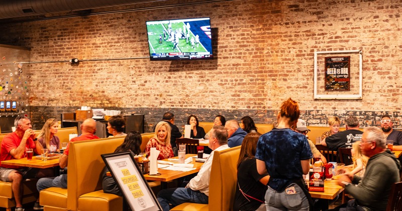 Interior, diner area, booths, guests eating, staff with order