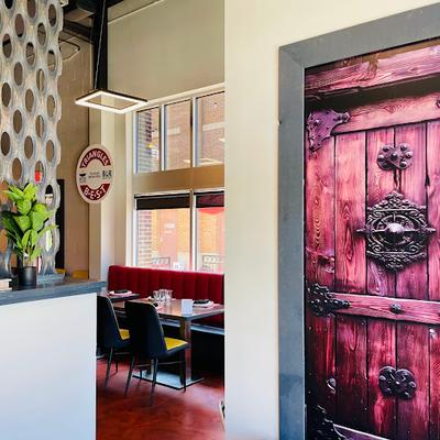 Angled view of an area with booth seating and tables set for guests.