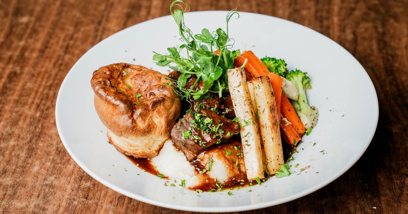 Braised beef, mashed potatoes, veggies, and Yorkshire pudding