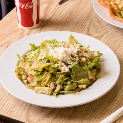 Grilled chicken salad with lettuce, avocado, tomato, corn, beans, cucumber, and ranch.