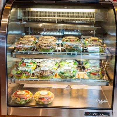 Packaged salads in a refrigerated display.