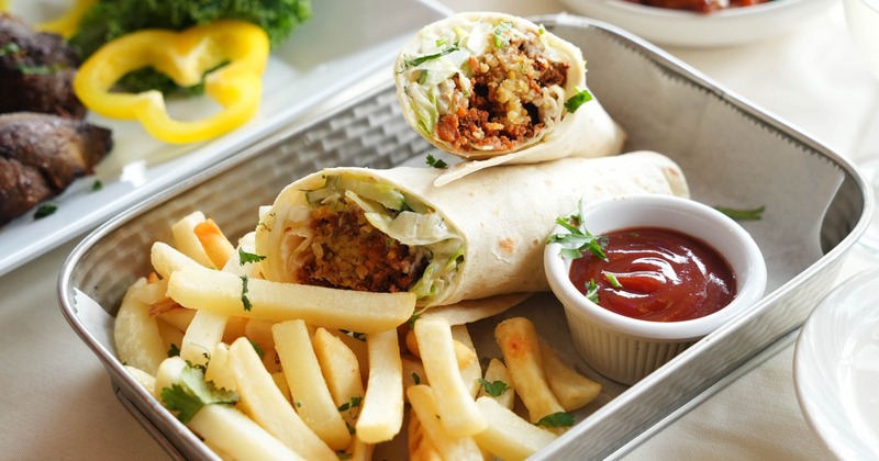 Falafel wrap served with sides of fries and a dipping sauce