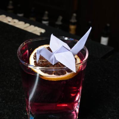A served drink with an origami garnish.