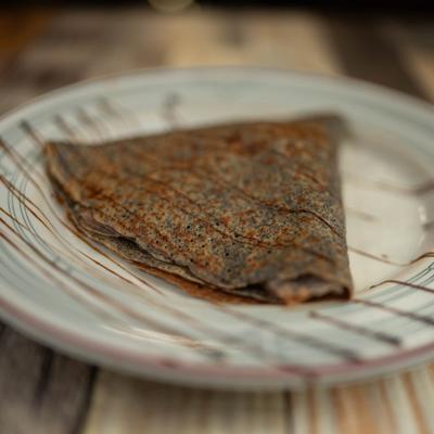 Vegan Crepe drizzled with chocolate sauce.