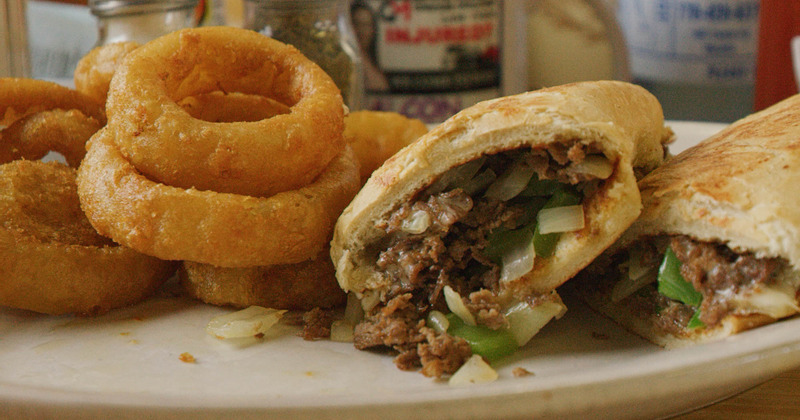 Philly cheesesteak and onion rings served