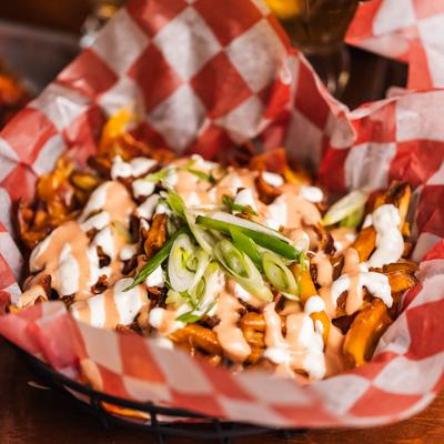 Fries topped with melted cheddar, bacon bits, ranch, house sauce, and scallions.