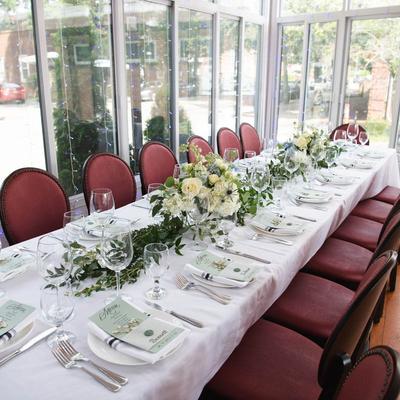 Elegant dining table setting with glassware and floral centerpieces.