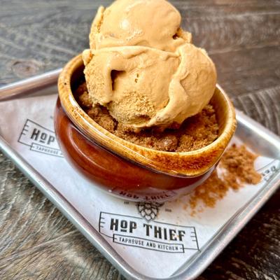 Peach cobbler topped with ice cream.