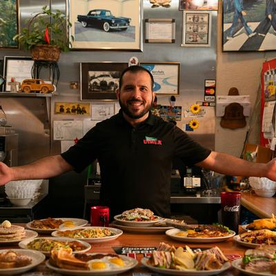 A staff member posing behind a full table.