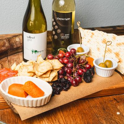 Hot Blooded Signature Charcuterie with white wine bottles.