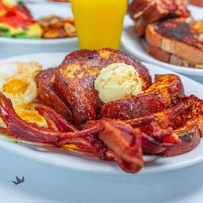 French toast with fried eggs and bacon, side view.