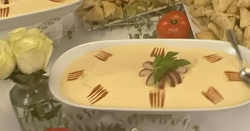 Hummus dish garnished with radish and mint on a buffet table