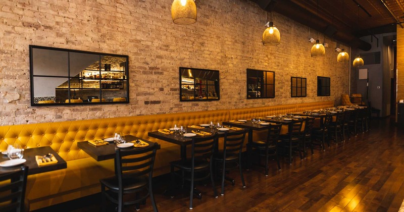 A dining area by the wall with mirrors, booths and tables setup for a diner.