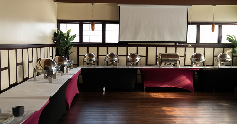 Interior, banquette area, long table setups with metal catering containers