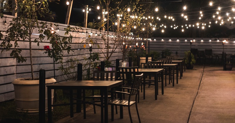 Exterior, tables and chairs lined up, decorative lights