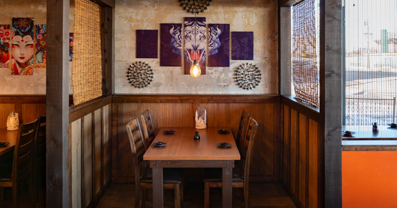 Interior, private table for four by a a wall decorated with a painting of a white tiger