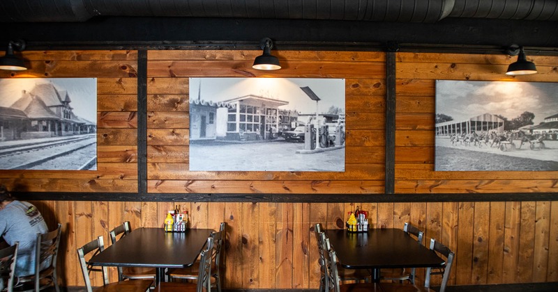Interior, two tables and chairs with pictures on the wall