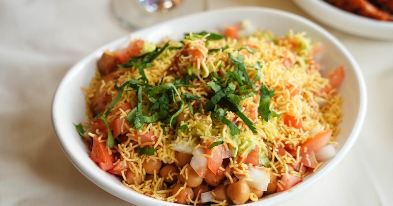 Aloo Tikki Chaat topped with thin crispy noodles and fresh coriander