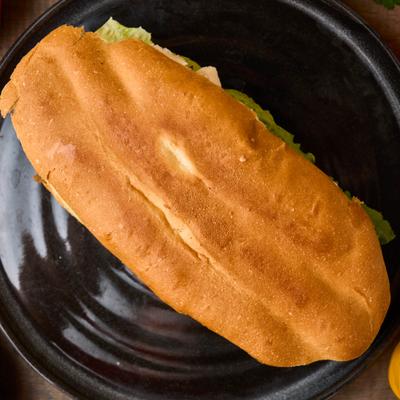 Mexican torta sandwich on a black plate.