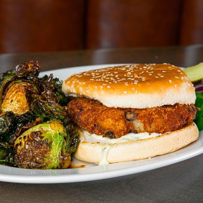 A potato and black bean burger served with fried brussels sprouts.