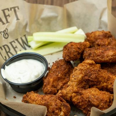 Broasted wings with sauce and celery.