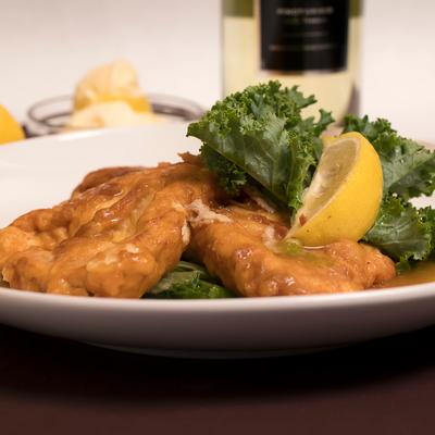 Egg battered haddock filets served over escarole.