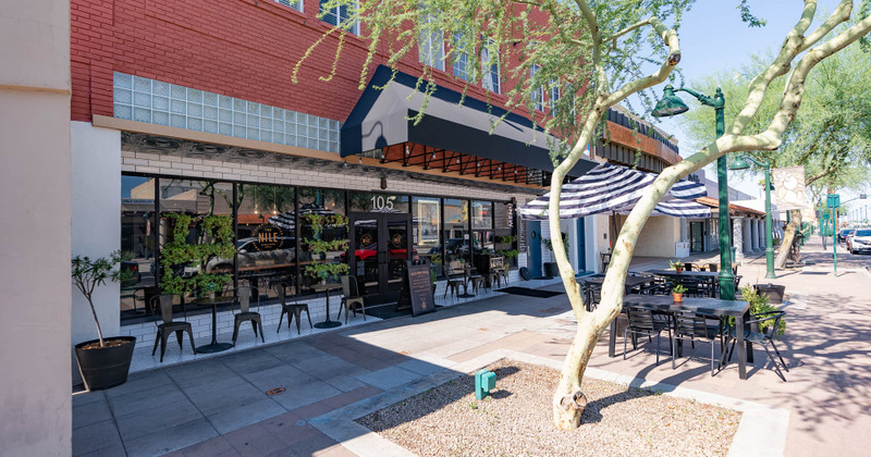Exterior - Blue and white patio umbrellas, outside seating area with modern tables and chairs