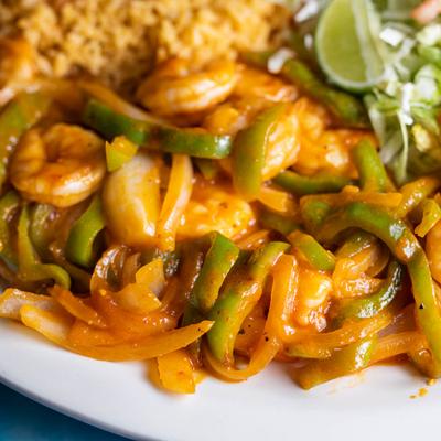 Shrimp, cooked with garlic sauce, onions and green peppers, with rice, sour cream and salad