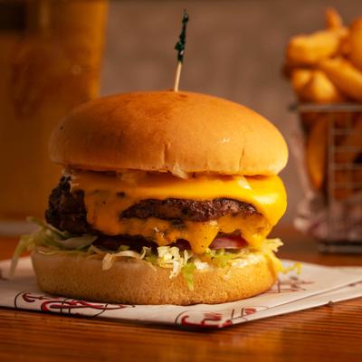 Double cheeseburger with melted cheddar and lettuce on a toasted bun.