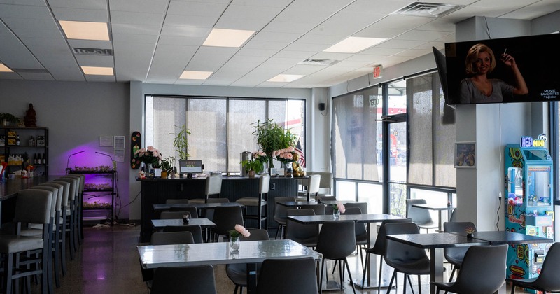 Interior, dining area, restaurant entrance, tables with chairs, checkout counter in the back