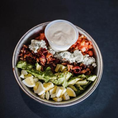 Cobb salad, with romaine, avocado, bacon, blue cheese, grape tomatoes, and egg.