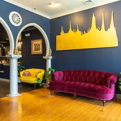 Lounge area with tufted velvet sofa and a prominent yellow skyline wall art piece.