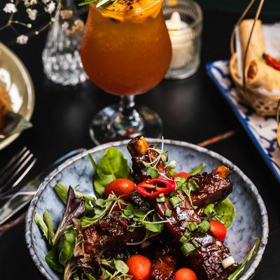 Seasoned pork spare ribs with barbecue sauce, served with a cocktail.