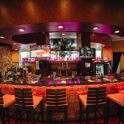 Restaurant bar area with seating and ambient lighting.