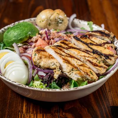 Chicken Cobb Salad, with boiled egg, avocado, tomato, onion, bacon, and blue cheese dressing.
