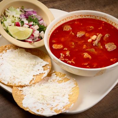 Pozole soup served with sour cream and cheese tostadas.