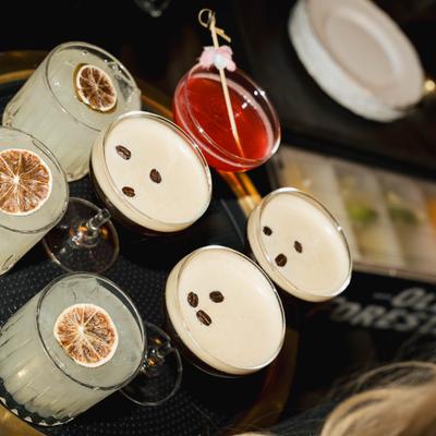 A tray of cocktails featuring espresso martinis, citrus cocktails, and a pink drink.
