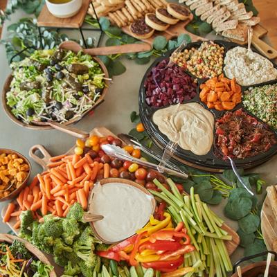 A large, vibrant catering spread featuring a variety of dishes.