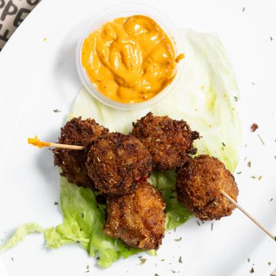 Crab poppers with dipping sauce and lettuce.