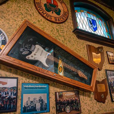 Wall decorations with a signed electric guitar in a display case.