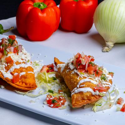 Empanadas topped with cheese, sour cream, and salsa.