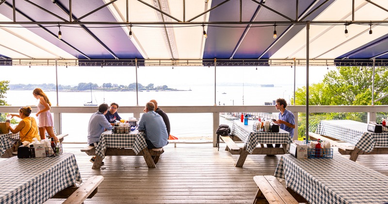 Roof covered terrace with guests sitting at tables