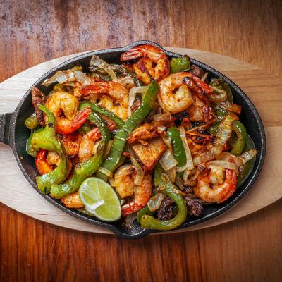 Mexican Fajitas with shrimp and beef, served in a skillet.