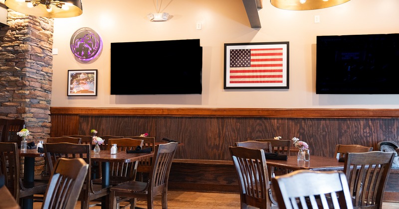 Interior space, dining area with dining tables, TV sets on the wall