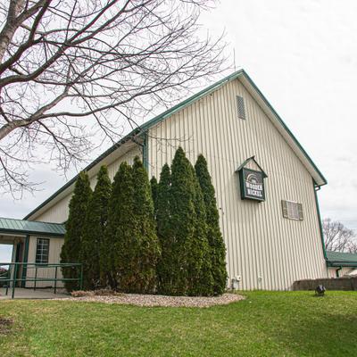 White barn restaurant building beside grassy lawn.