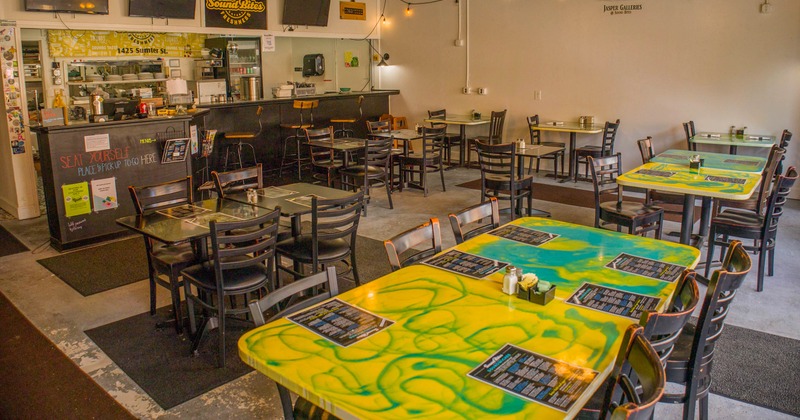 Interior view of a casual dining restaurant with colorful marbled tabletops, black chairs