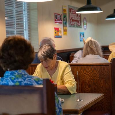 Interior, seated guests in booths.