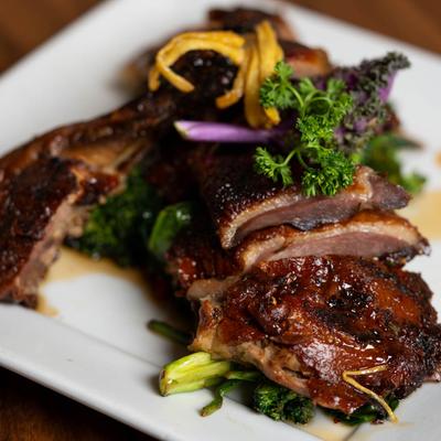 Sliced honey-roasted duck with vegetable garnish.
